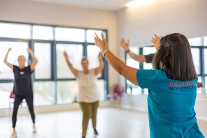 Therapeutin von Balance Aschaffenburg leitet Bewegungsgruppe an, gesundheitsfördernde Übungen, Gruppenaktivität, helle Trainingsräume