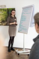 Mitarbeiterin von Balance Aschaffenburg erklärt Inhalte auf Flipchart im Rahmen eines Seminars, Fortbildung, Schmerzbewältigung, Patientenschulung
